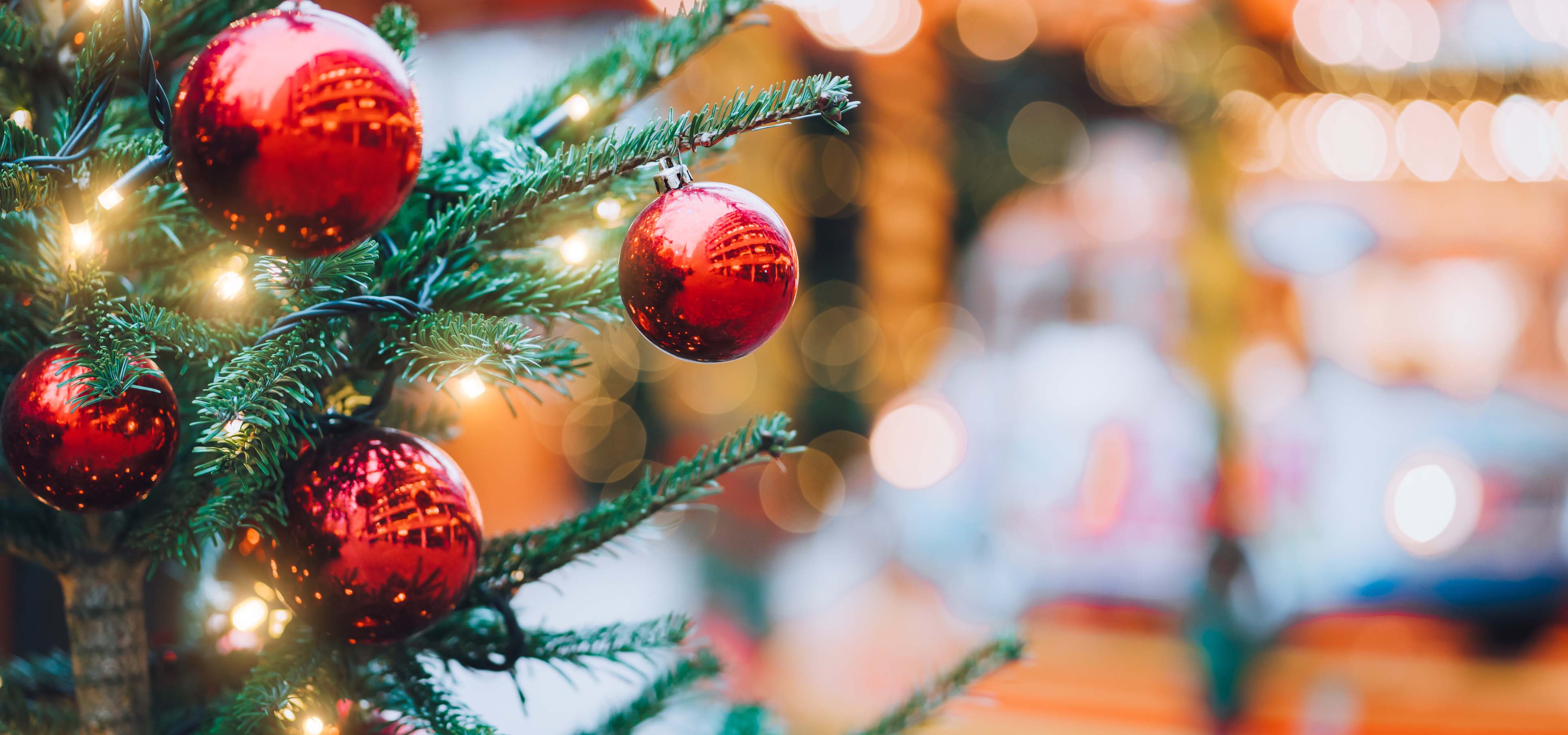 Red ornaments and lights on a Christmas tree